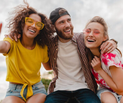 happy young company of smiling friends sitting in park